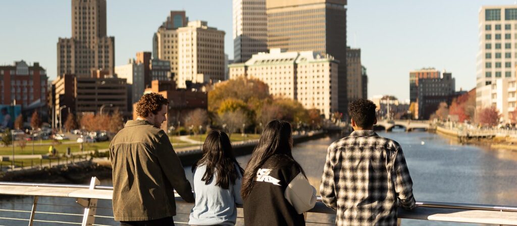 Providence College students walking in downtown Providence along the waterfront on a fall day